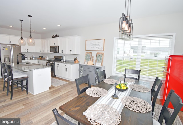 dining space featuring sink and light hardwood / wood-style floors