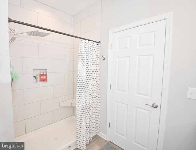 bathroom featuring wood-type flooring and a shower with shower curtain