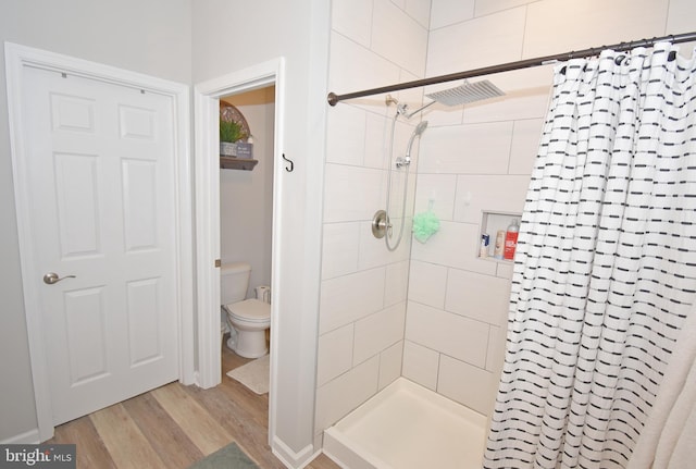 bathroom featuring a shower with curtain, hardwood / wood-style floors, and toilet