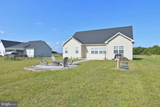 back of house featuring a yard and an outdoor fire pit