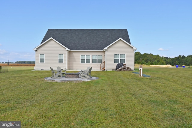 back of property with a yard, a patio, and an outdoor fire pit