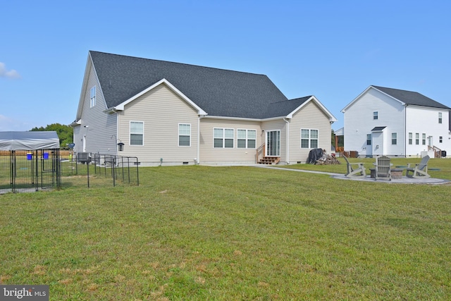 back of house featuring a yard and an outdoor fire pit