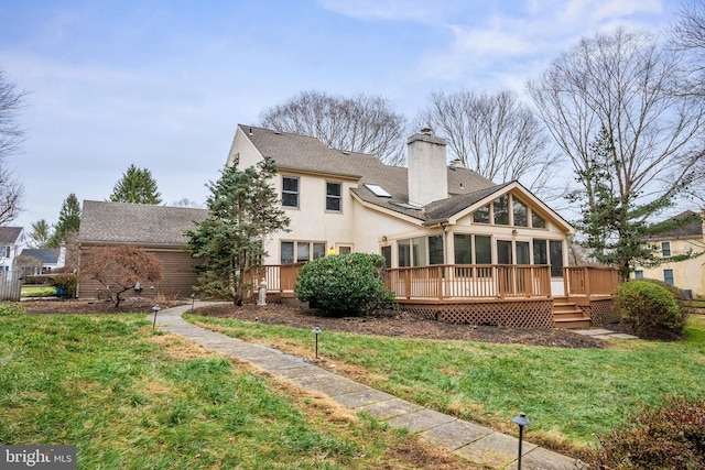 rear view of house featuring a sunroom, a lawn, and a wooden deck