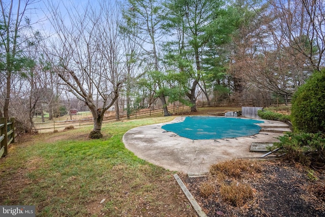 view of swimming pool with a yard