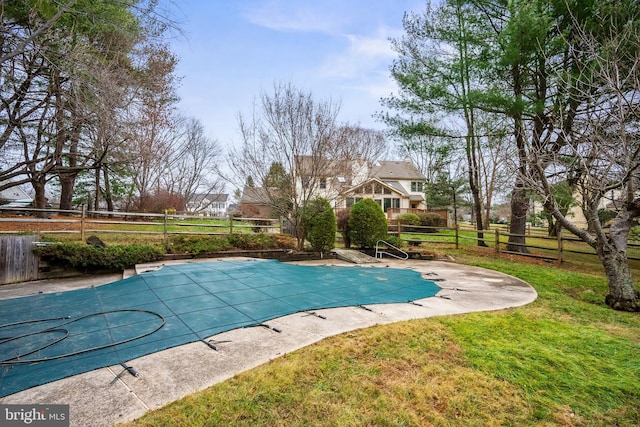 view of pool featuring a patio area and a yard