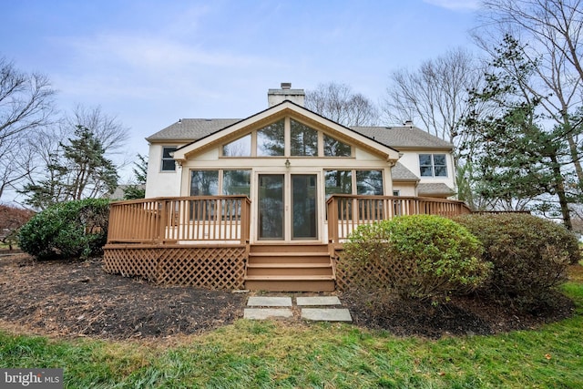 rear view of house featuring a sunroom and a deck