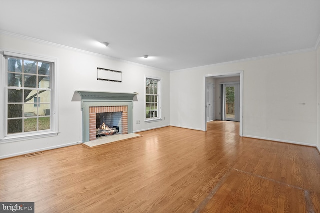 unfurnished living room featuring a fireplace, wood-type flooring, and ornamental molding