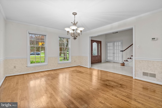 interior space featuring a chandelier, french doors, hardwood / wood-style flooring, and ornamental molding