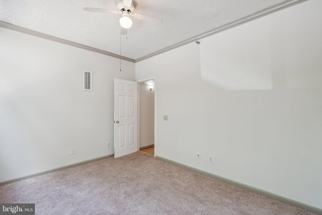 spare room featuring carpet, a textured ceiling, crown molding, and ceiling fan