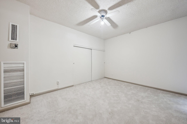 interior space featuring a textured ceiling, a closet, ceiling fan, and light colored carpet