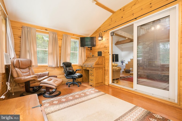 interior space featuring light hardwood / wood-style flooring, wooden walls, and vaulted ceiling