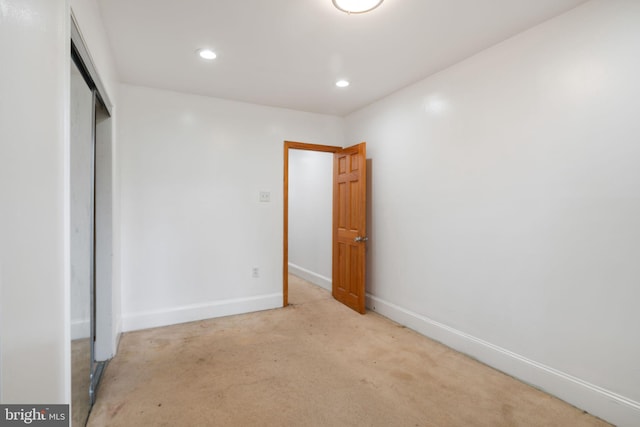 unfurnished bedroom with light carpet and a closet