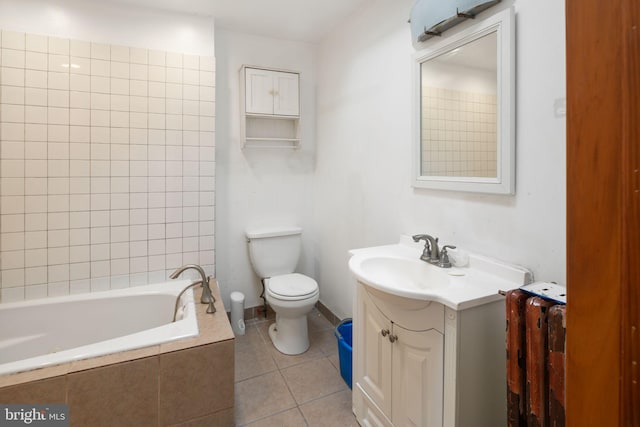 bathroom featuring tiled tub, vanity, tile patterned flooring, and toilet