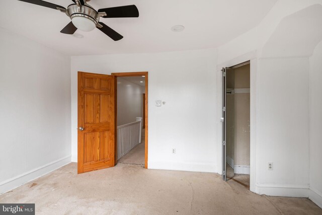 unfurnished bedroom featuring ceiling fan, light colored carpet, and a closet