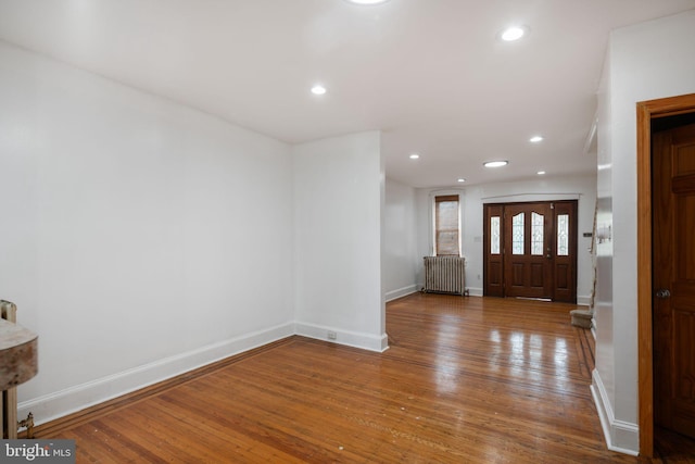 foyer with radiator and hardwood / wood-style flooring