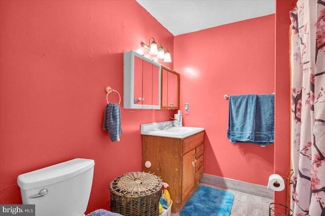 bathroom featuring walk in shower, vanity, toilet, and hardwood / wood-style floors