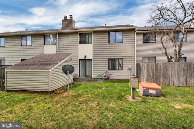 rear view of property with a lawn