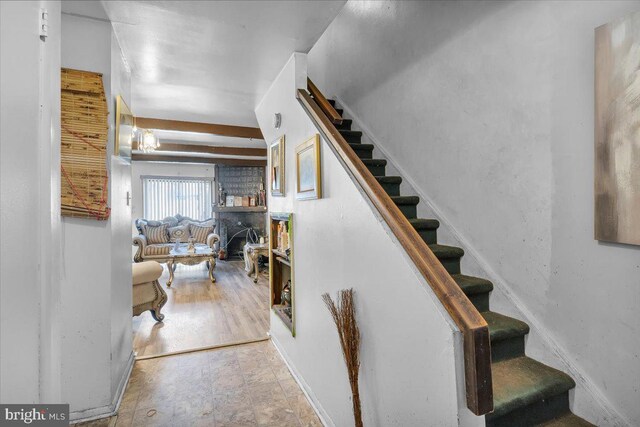 stairway with beam ceiling and tile patterned floors