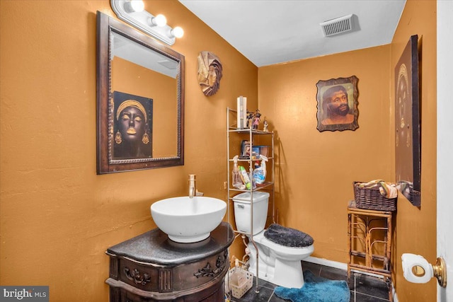 bathroom featuring tile patterned floors, toilet, and vanity