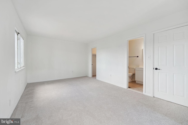 unfurnished bedroom with carpet flooring and connected bathroom