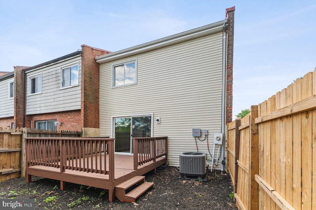 rear view of property featuring a wooden deck and central AC unit