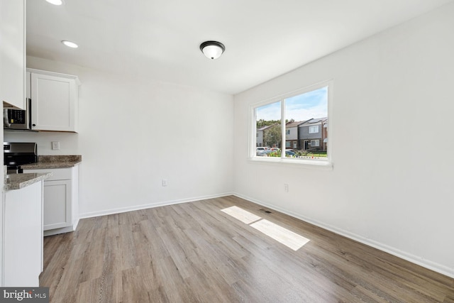 unfurnished dining area with light wood-type flooring