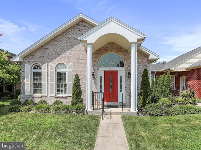 property entrance with a lawn