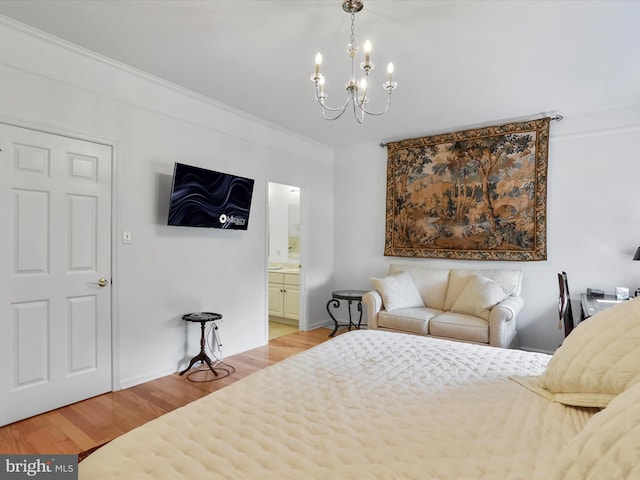 bedroom with light hardwood / wood-style floors, a chandelier, crown molding, and ensuite bathroom