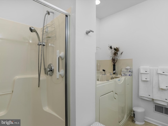 bathroom with an enclosed shower and washer / dryer