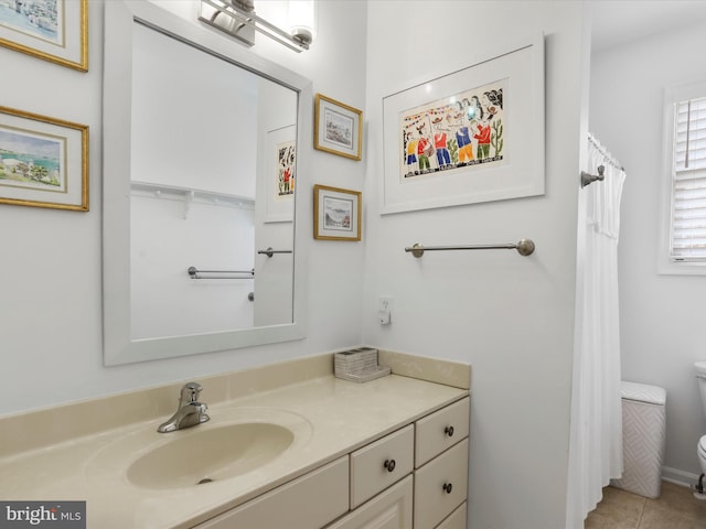 bathroom with toilet, vanity, and tile patterned flooring