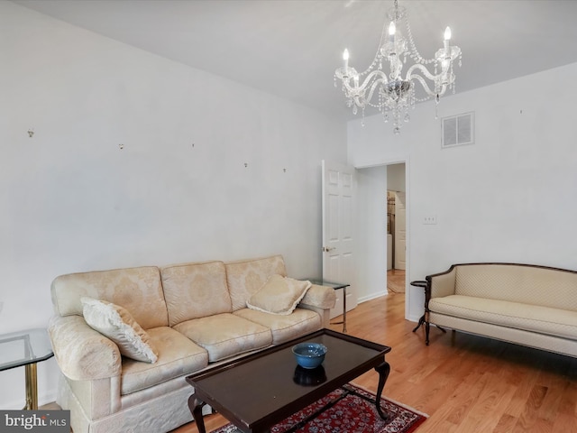 living room featuring an inviting chandelier and light hardwood / wood-style flooring