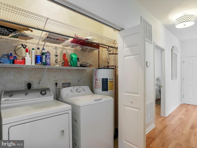 laundry room with light hardwood / wood-style floors, water heater, and separate washer and dryer