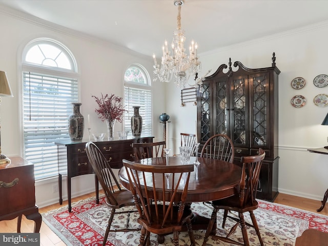 dining room featuring light hardwood / wood-style floors, an inviting chandelier, and crown molding