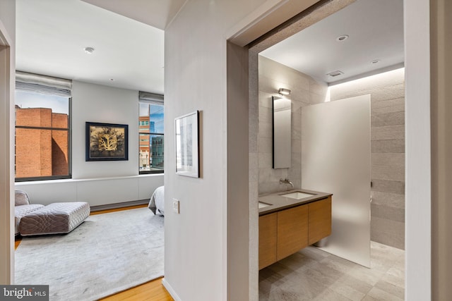 bathroom with double vanity and wood-type flooring