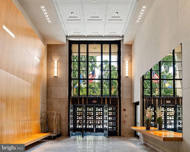 wine room with tile walls, a wealth of natural light, and a high ceiling