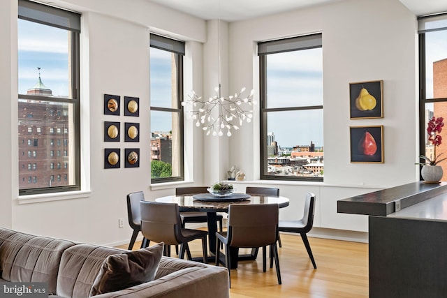 dining room with light hardwood / wood-style flooring and an inviting chandelier