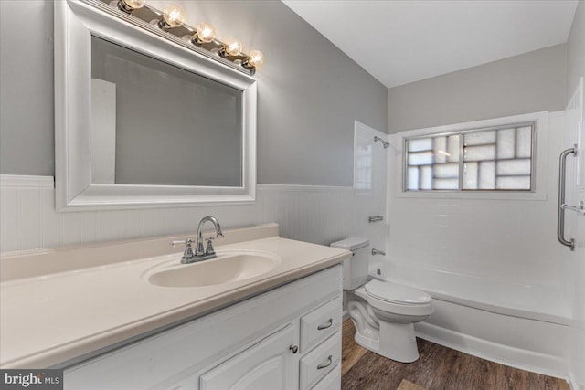 full bathroom featuring tiled shower / bath, vanity, hardwood / wood-style floors, and toilet