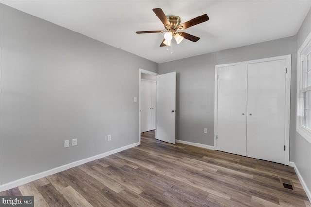 unfurnished bedroom featuring a closet, wood-type flooring, and ceiling fan