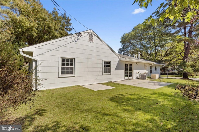 rear view of house with a lawn, central AC, french doors, and a patio area