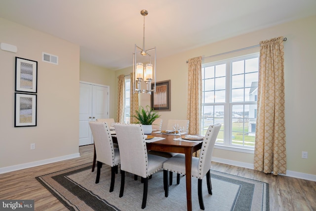 dining room with hardwood / wood-style flooring and a chandelier