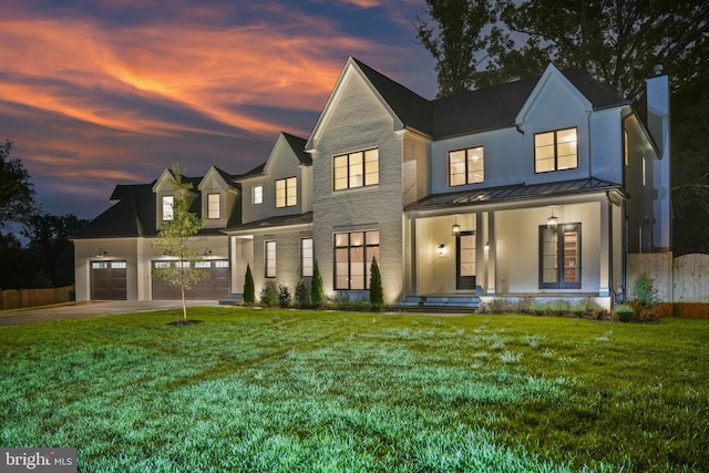 modern inspired farmhouse with a yard, covered porch, and a garage