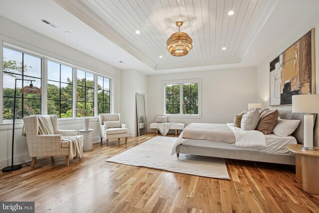 bedroom with a tray ceiling, wood ceiling, and light wood-type flooring