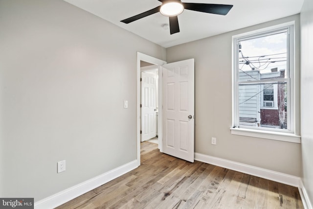 empty room with light wood-type flooring and ceiling fan