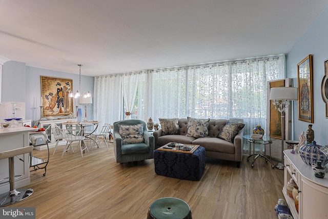 living room featuring light wood-type flooring and an inviting chandelier