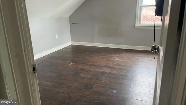 additional living space with lofted ceiling and dark wood-type flooring