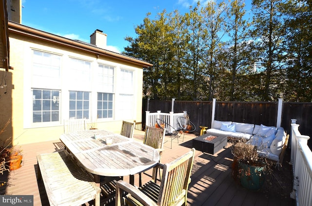 wooden terrace with an outdoor living space with a fire pit