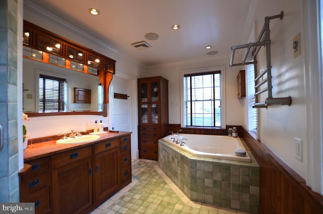 bathroom with tiled tub, ornamental molding, tile patterned floors, and vanity