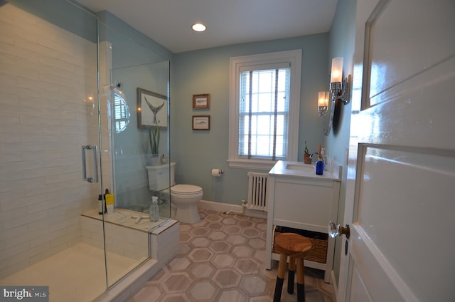 bathroom with toilet, radiator, tile patterned floors, a shower with door, and vanity