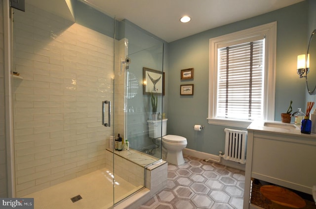 bathroom with radiator, toilet, vanity, tile patterned flooring, and a shower with shower door