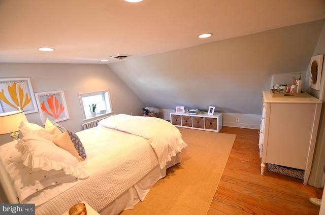 bedroom with lofted ceiling and light hardwood / wood-style floors